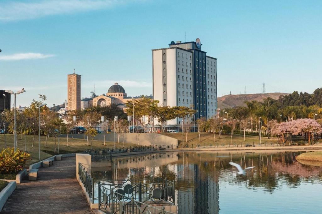 um horizonte da cidade com um lago e um edifício em Hotel Rainha dos Apóstolos em Aparecida