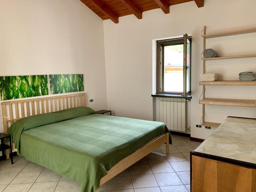 - une chambre avec un lit vert et une fenêtre dans l'établissement Il Nido, à Castelletto sopra Ticino