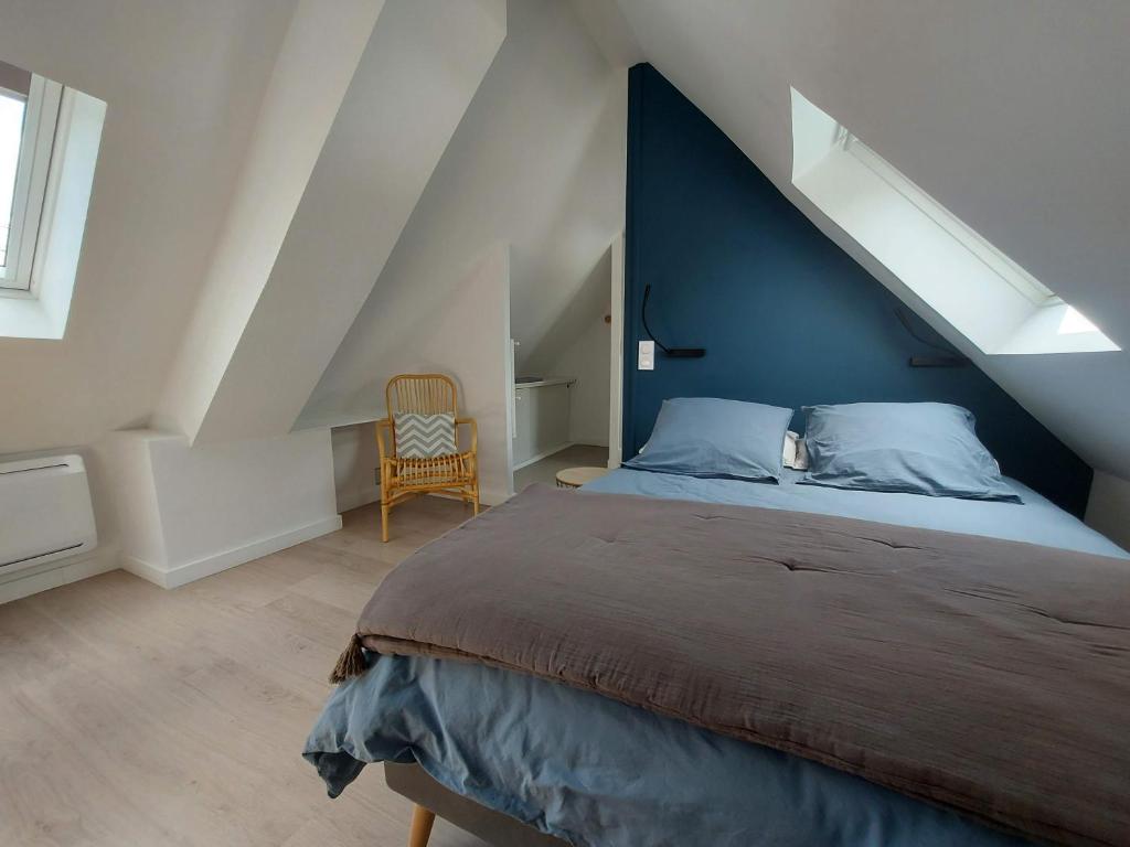 ein Schlafzimmer mit einem großen Bett mit blauer Wand in der Unterkunft Havre de paix et jardin tropical. Chambre privée in Le Rheu