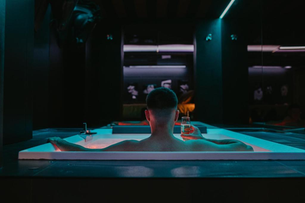 a man in a bath tub with a glass of wine at L'intimiste in Longeville-sur-Mer