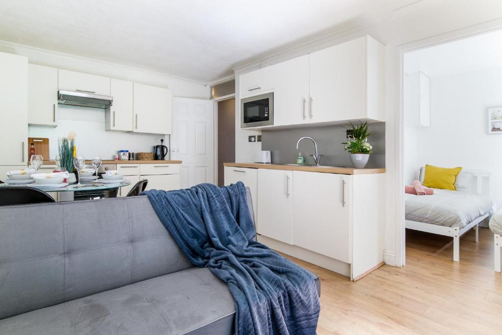 sala de estar con sofá y cocina en 2 Bed Apt, FREE Parking, Long Stay Discount en Luton