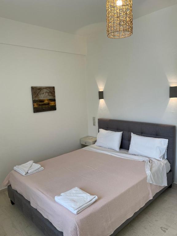 a bedroom with a bed with white sheets and a chandelier at Villa Sylvia in Matala