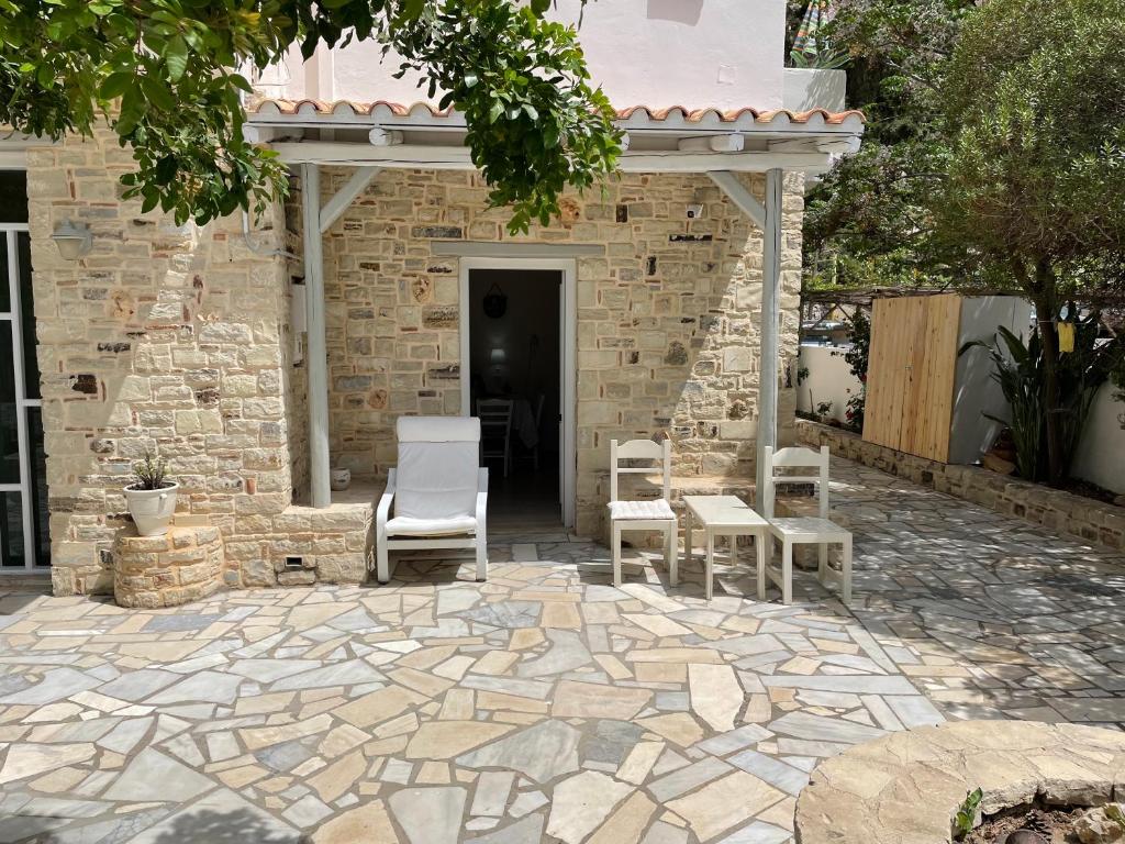 a stone patio with two chairs and a gazebo at Villa Sylvia in Matala