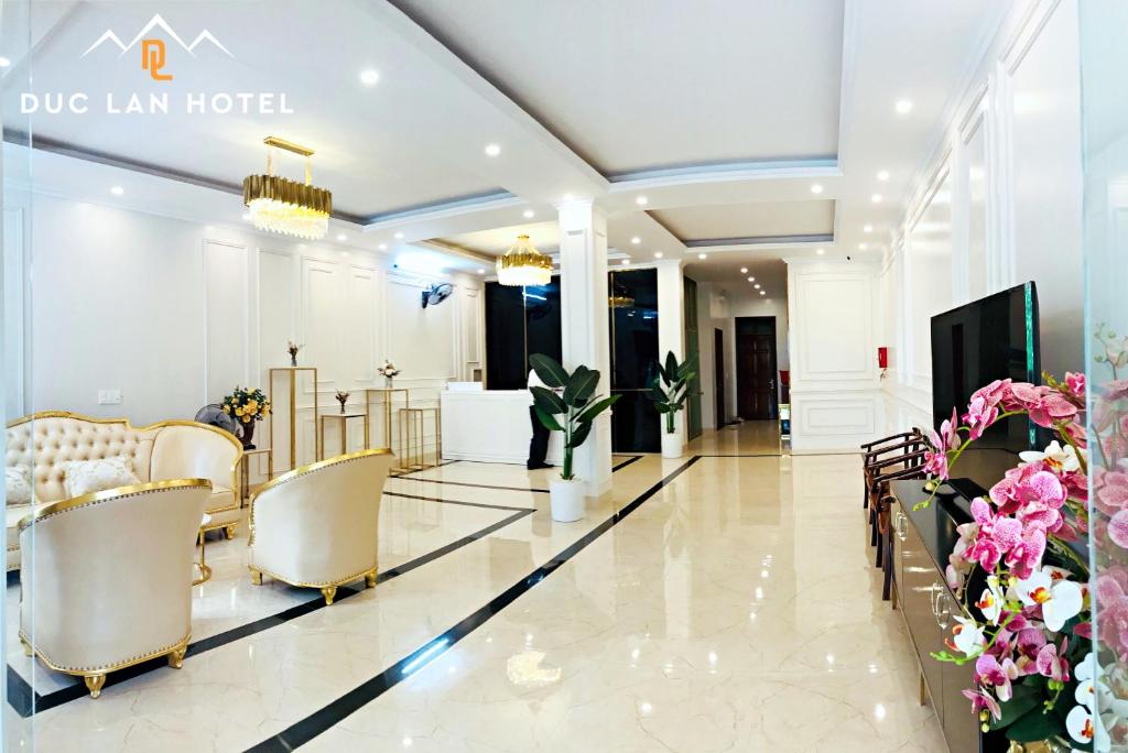 a lobby of a hotel with chairs and flowers at Đức Lan Hotel in Ha Giang