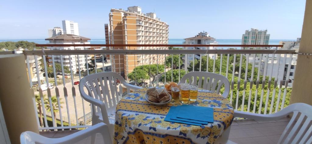 a table on a balcony with a view of the city at Condominio La Duna - Residence Puerto do Sol in Lignano Sabbiadoro