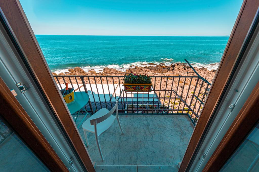 a view of the ocean from the balcony of a house at CATHENA HOLIDAY CEFALU in Cefalù