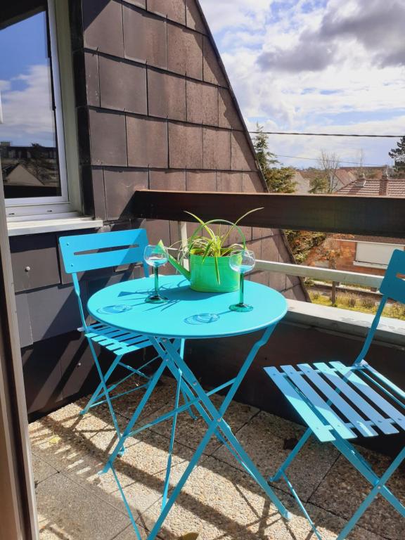 a table and chairs on a balcony with a plant at Lady Blue in Berck-sur-Mer