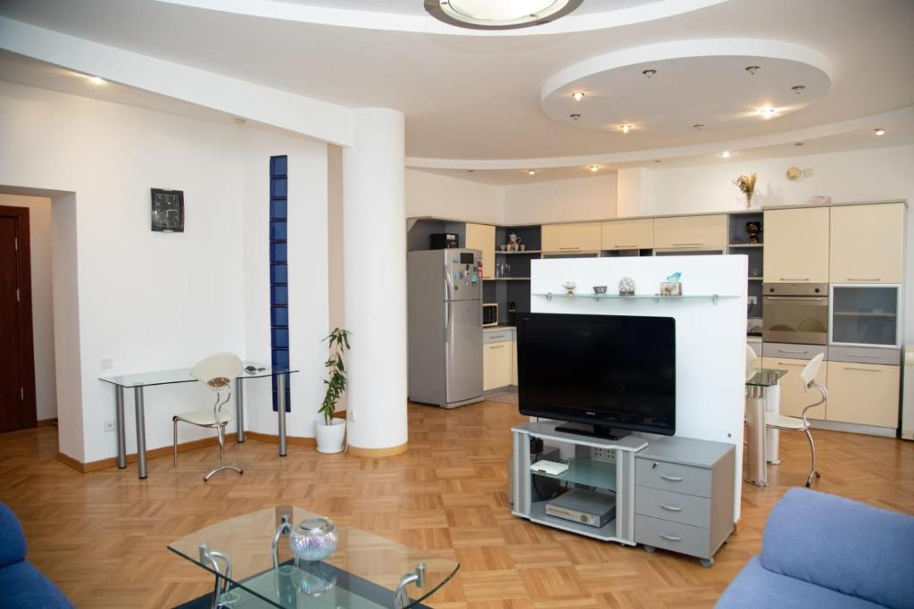 uma sala de estar com uma grande televisão e uma mesa em SAHIL GARDEN Uzeir Gadgibekova Street em Baku