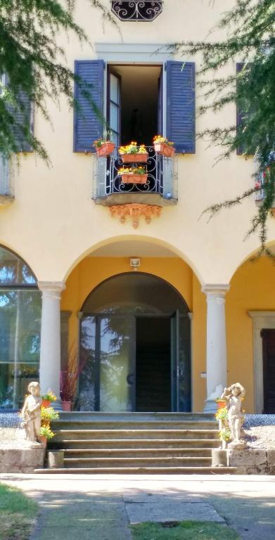 a building with a window and a balcony with flowers at Villa Riva Lago - Apartment with garden and parking in Tavernola Bergamasca
