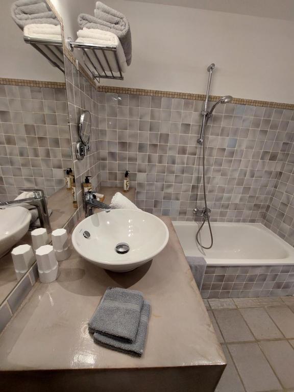 a bathroom with a sink and a bath tub at Hôtel les Bouis - Vue mer in Saint-Tropez