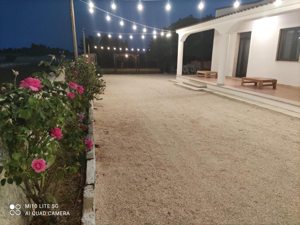 un patio di una casa con fiori e luci rosa di Casa vacanze Salento: Villa Charlotte a Torre Santa Susanna