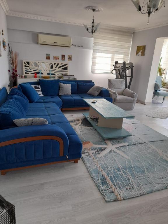 een woonkamer met blauwe banken en een tafel bij Lara holiday in Antalya