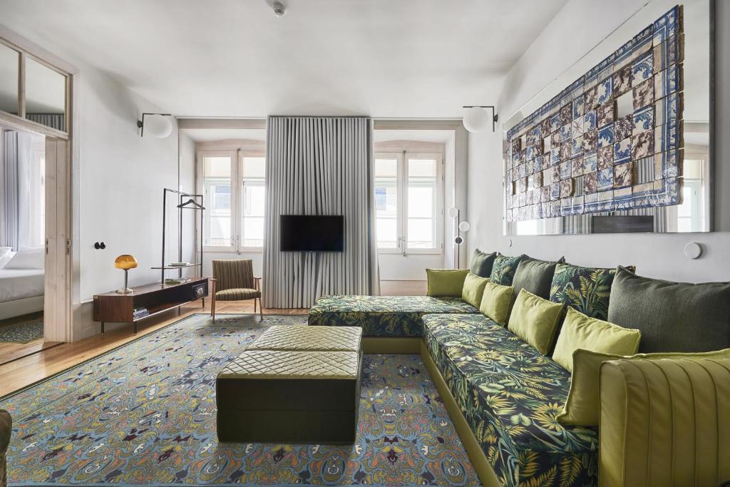 uma sala de estar com um sofá e uma televisão em Cais Urban Lodge em Lisboa