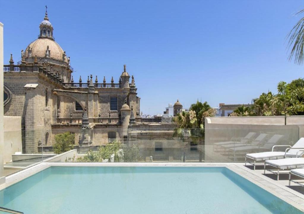 a swimming pool in front of a building at Hotel Bodega Tio Pepe in Jerez de la Frontera