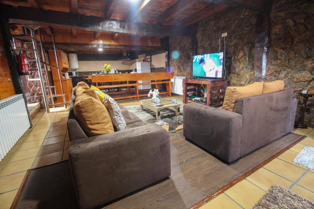 Sala de estar con 2 sofás y TV en Casa Viade, en Montalegre