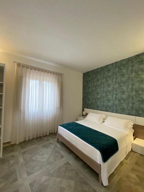 a bedroom with a large bed with a green headboard at B&B SoleLuna in Lampedusa