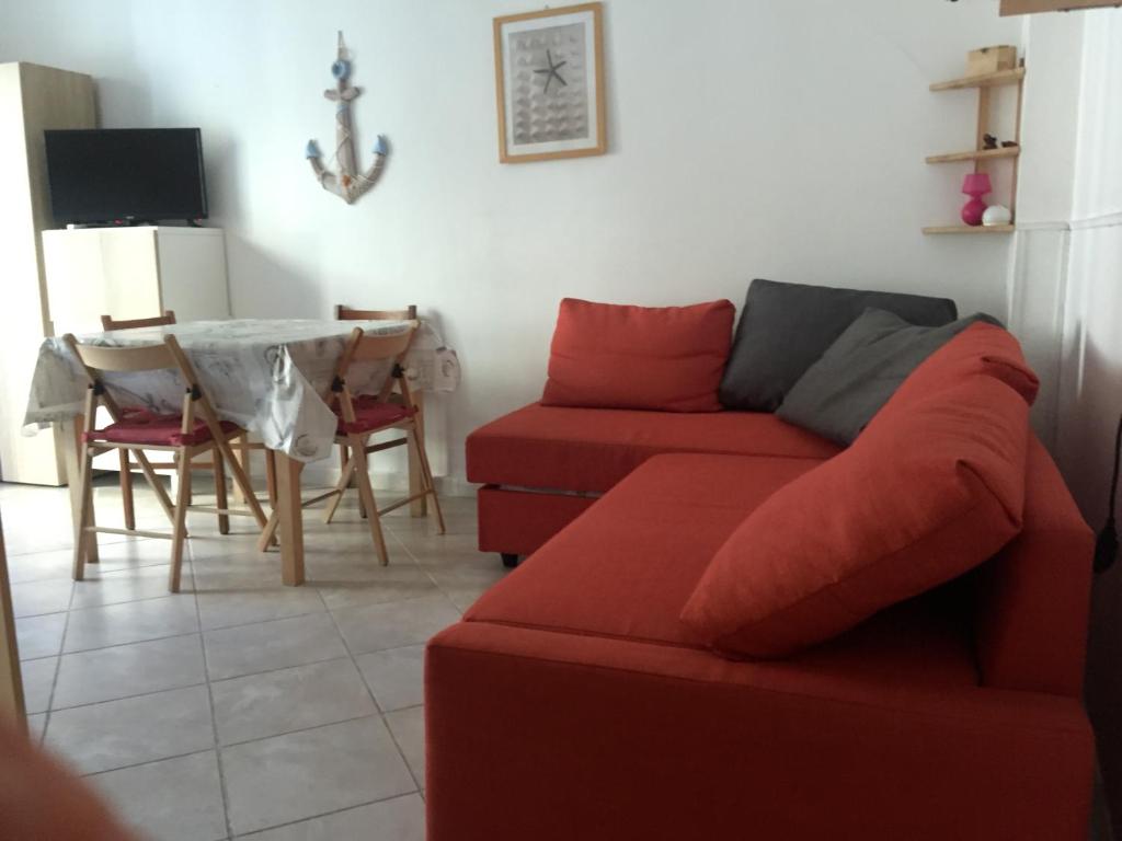 salon z czerwoną kanapą i stołem w obiekcie La Casina di TRILLI w Rapallo
