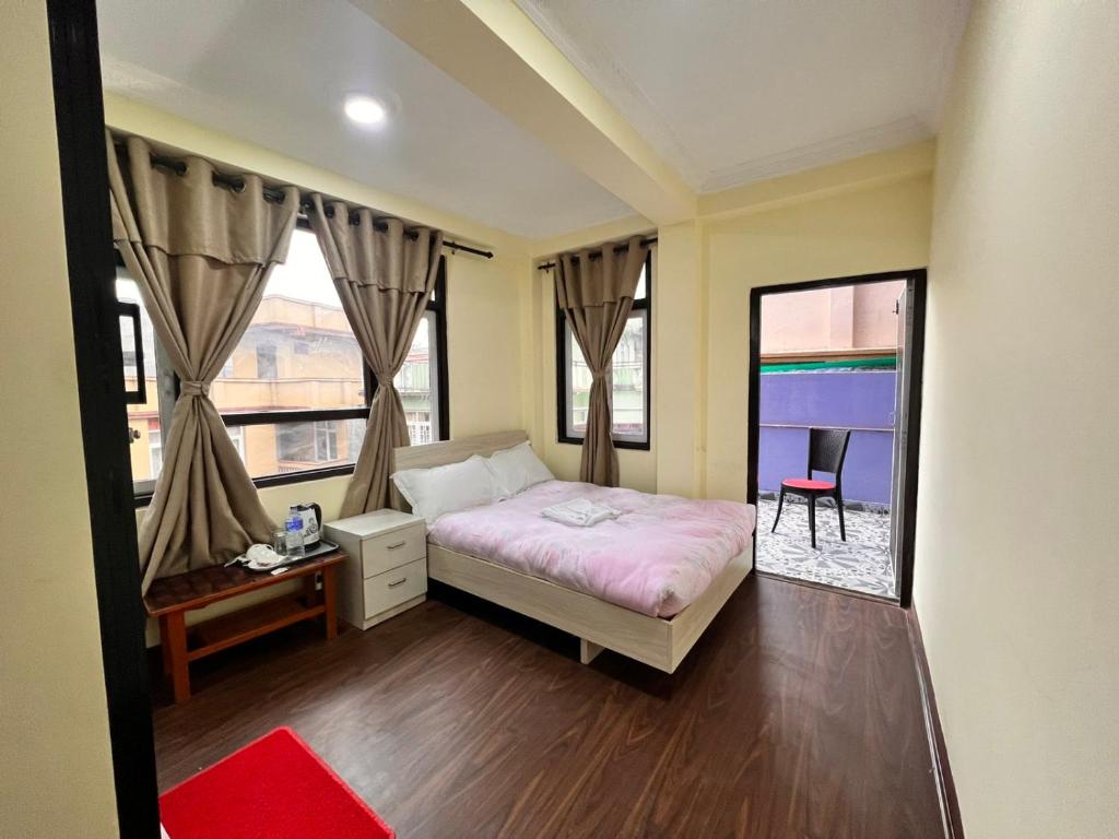1 dormitorio con cama y ventana grande en Lasa Kusa Homestay en Pātan