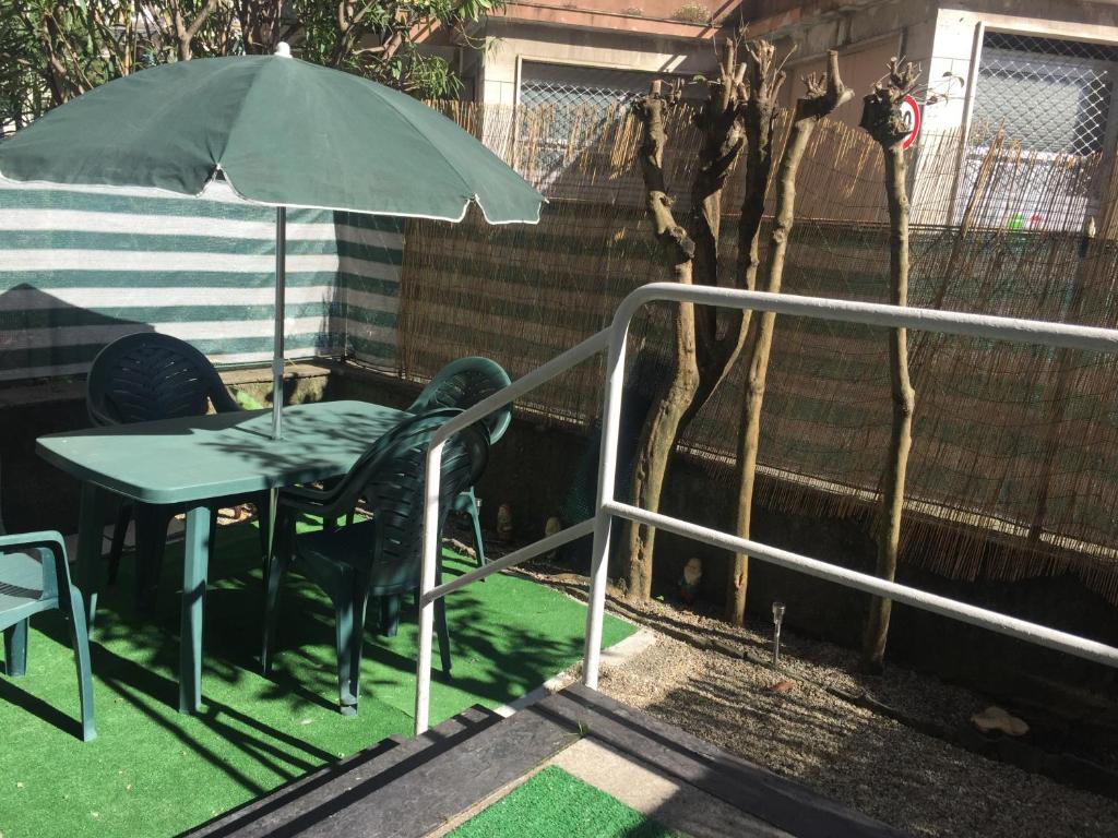 stół i krzesła z parasolem na patio w obiekcie La Casina di TRILLI w Rapallo