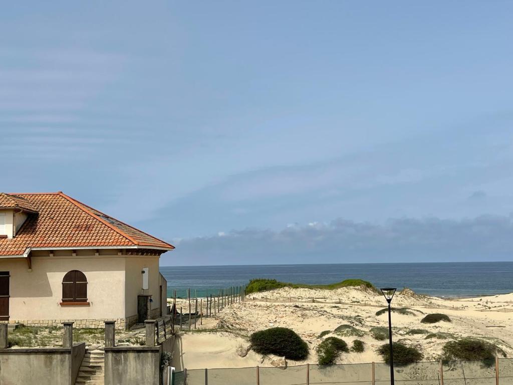 a house on the beach next to the ocean at L&#39;Abri Côtier in Mimizan