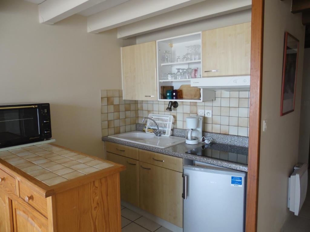 a small kitchen with a sink and a refrigerator at L&#39;Abri Côtier in Mimizan