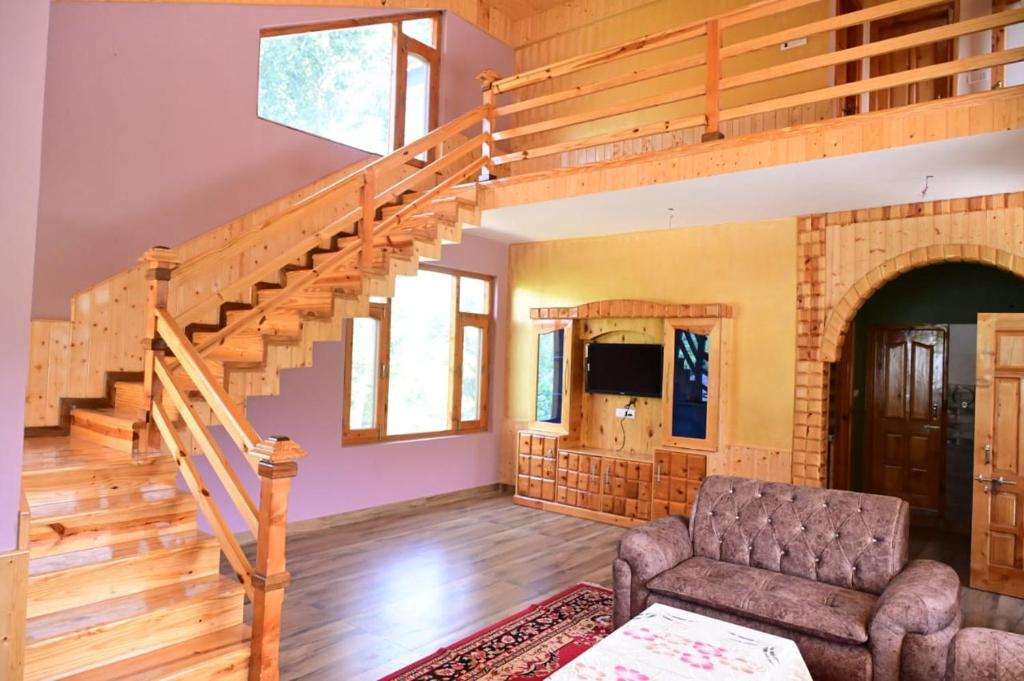 a living room with a staircase and a couch at Kavya Home Stay in Chachyot