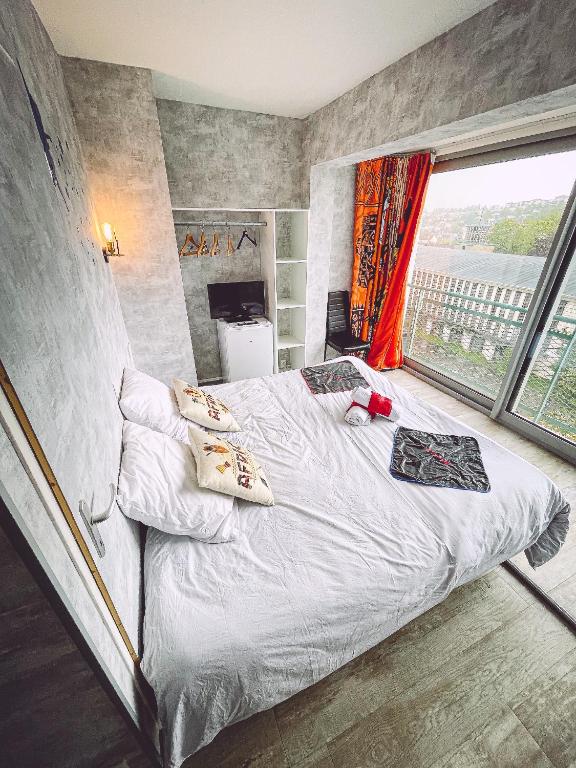 une chambre avec un lit et une grande fenêtre dans l'établissement Africa panoramique By Carl-Emilie, à Épinal