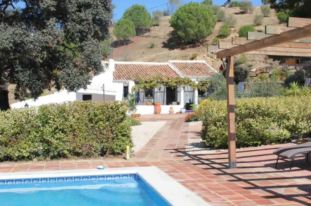 uma casa com uma piscina e um pátio em Finca El Sueño Andaluz em Villanueva de la Concepción