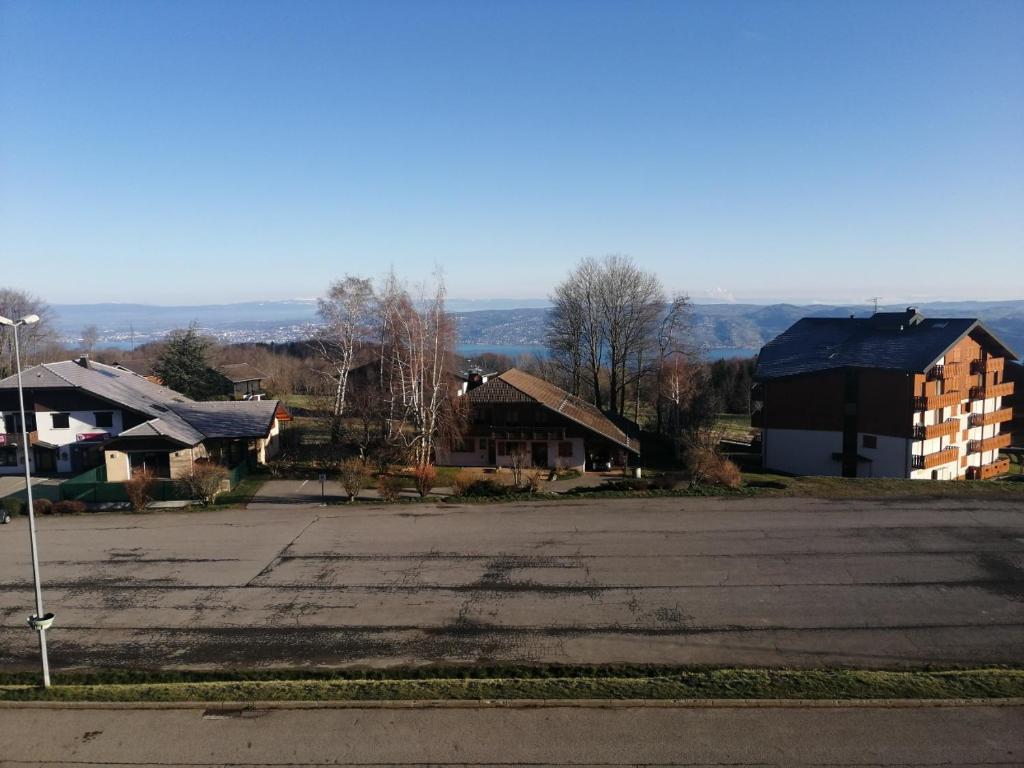 un parking vide avec des maisons et une rue dans l'établissement Le balcon des Memises, à Thollon-les-Mémises