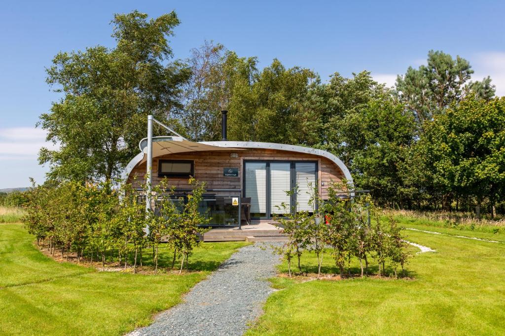 una casita en un campo con árboles en Fell View Park Escape Pods with hot tubs, en Kirkby Lonsdale