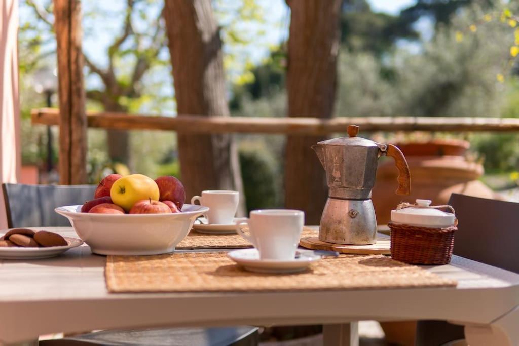 a table with a bowl of fruit and a tea kettle at Agriturismo De Santis in Castiglioncello