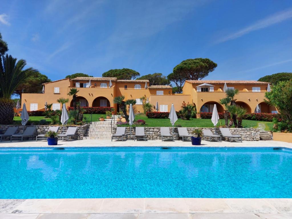 a villa with a swimming pool and a resort at Hôtel les Bouis - Vue mer in Saint-Tropez