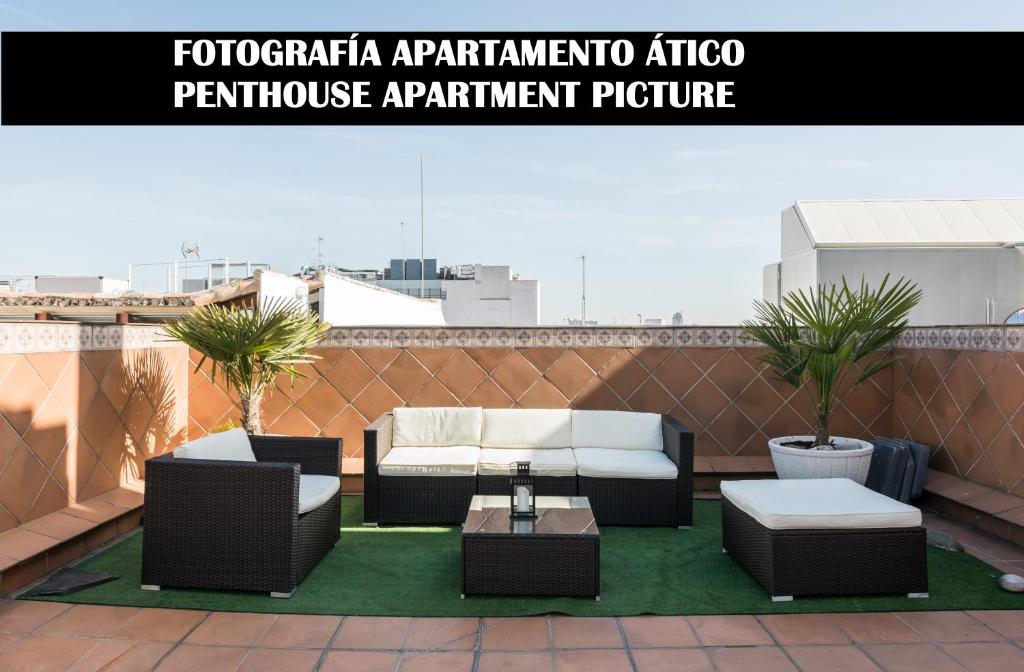 patio z 2 krzesłami i stołem na dachu w obiekcie Apartments Madrid Principe 2 w Madrycie