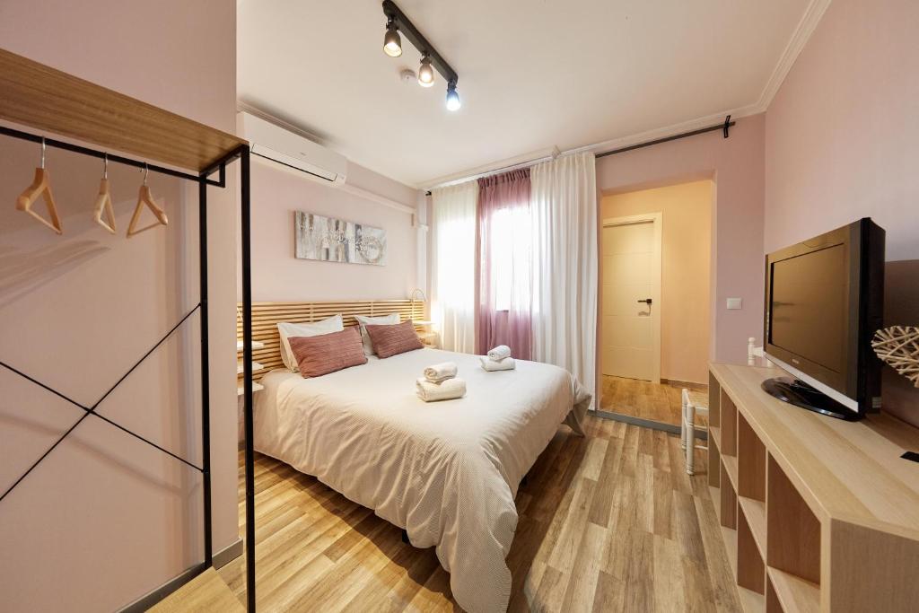 a bedroom with a bed and a flat screen tv at Casa SaMARa in Alicante