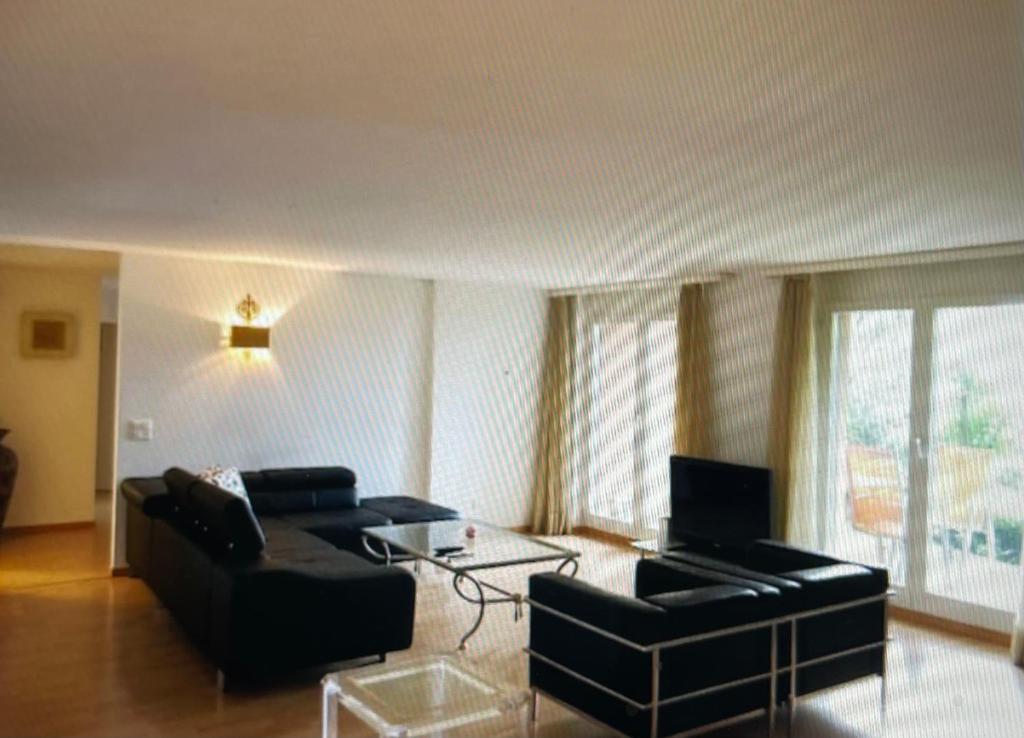 uma sala de estar com um sofá e uma mesa em Centrally located, Spacious Modern Apartment em Zürich