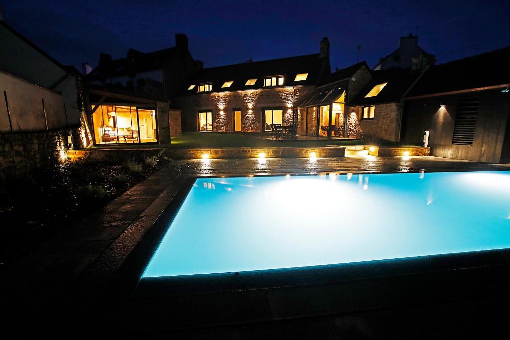 ein Schwimmbad vor einem Haus in der Nacht in der Unterkunft Villa Les Sternes in Larmor-Baden