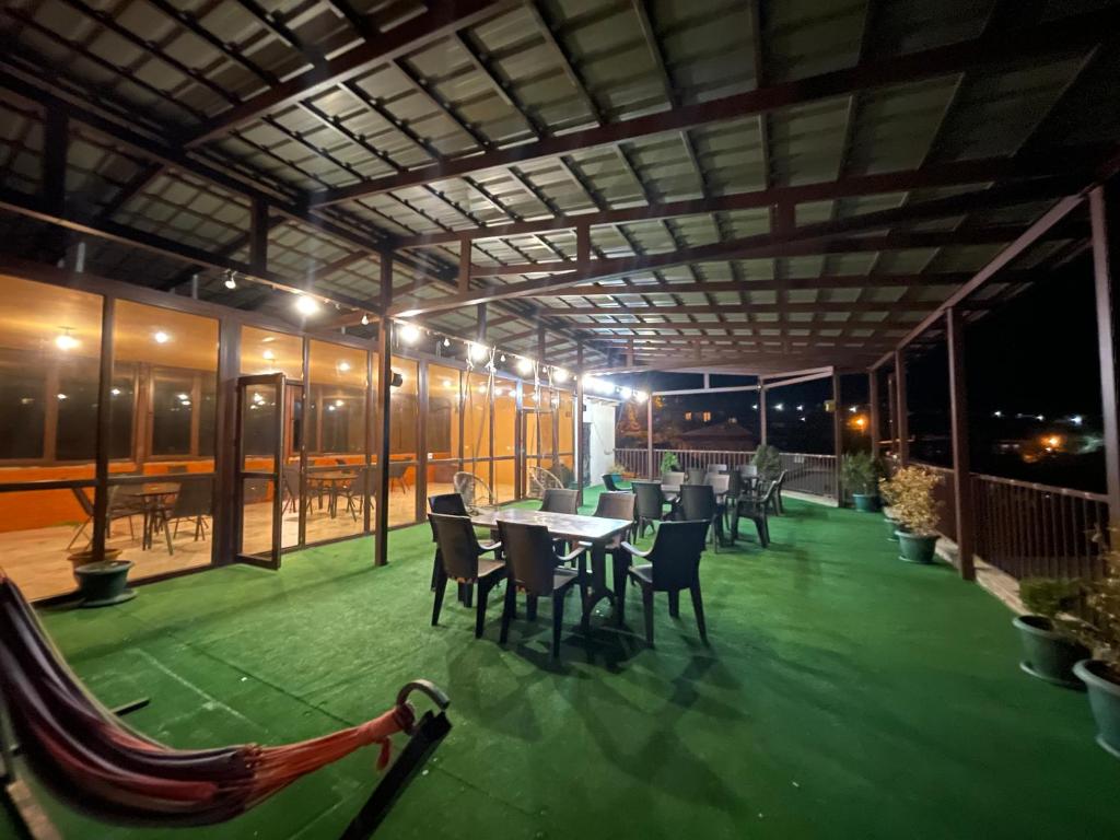 a covered patio with tables and chairs on a building at Guest House Royal Comfort With Terrace in Kutaisi