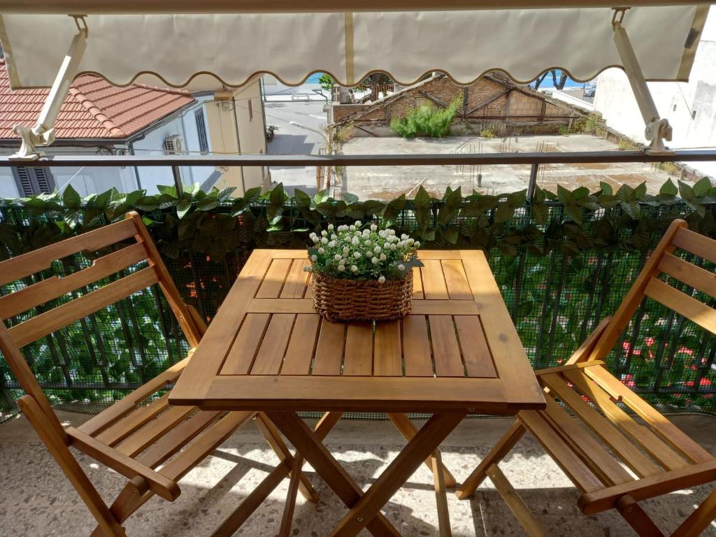 uma mesa de piquenique com duas cadeiras e um cesto de flores em IL VELIERO em Scilla