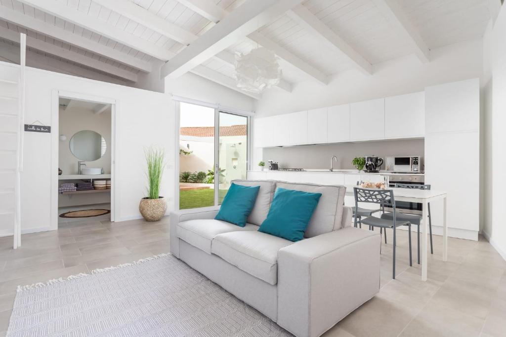 Una sala de estar con un sofá blanco y una mesa. en Bianca - Marlù House -, en Cabras
