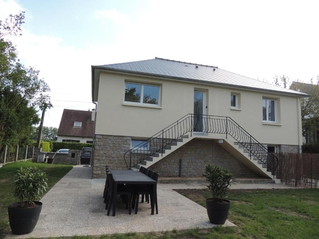 a house with a staircase and a table in front of it at Gîte entre terre et baie in Pontorson