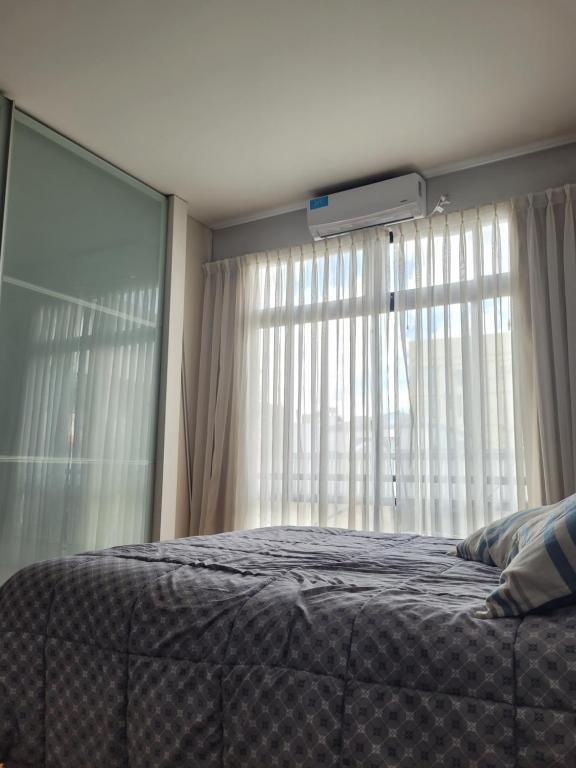 1 dormitorio con cama y ventana grande en Un espacio cálido ideal para desconectar. en Buenos Aires