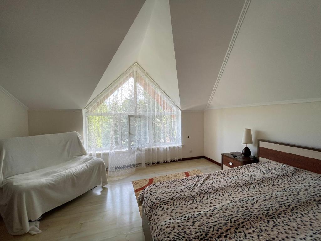 a bedroom with two beds and a large window at Гостевой дом в пансионате Солнышко, городок VIP-2 in Chok-Tal
