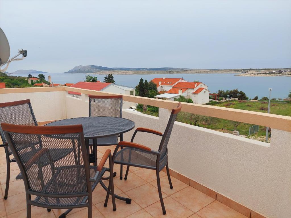 a balcony with a table and chairs and a view of the water at Apartments Donadic I, Caska in Novalja