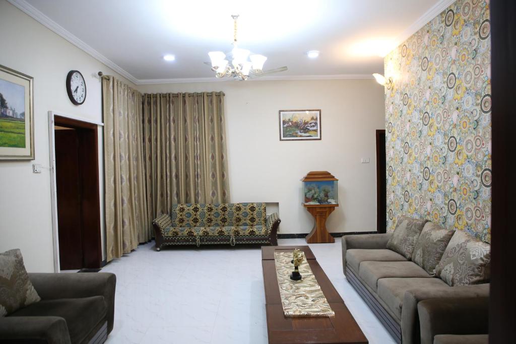 een woonkamer met een bank en een tafel bij 6 Bedroom private home in Dha Lahore- Phase1 Entire House in Lahore