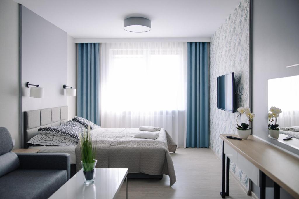 a bedroom with a bed and a living room at Apartament Turysta in Licheń Stary