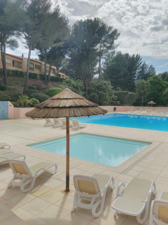 une terrasse avec des chaises et un parasol ainsi qu'une piscine dans l'établissement LE VALLON DU ROY plage à 600m à pieds, à Sanary-sur-Mer