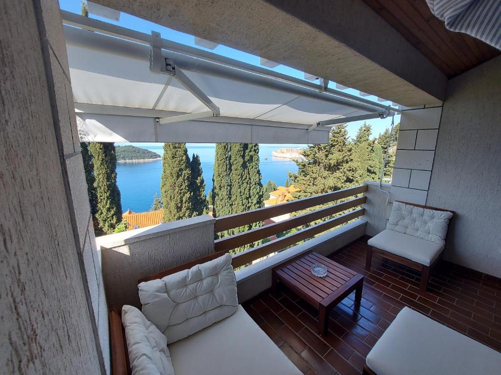 einen Balkon mit weißen Möbeln und Blick auf das Wasser in der Unterkunft Villa Maria in Dubrovnik