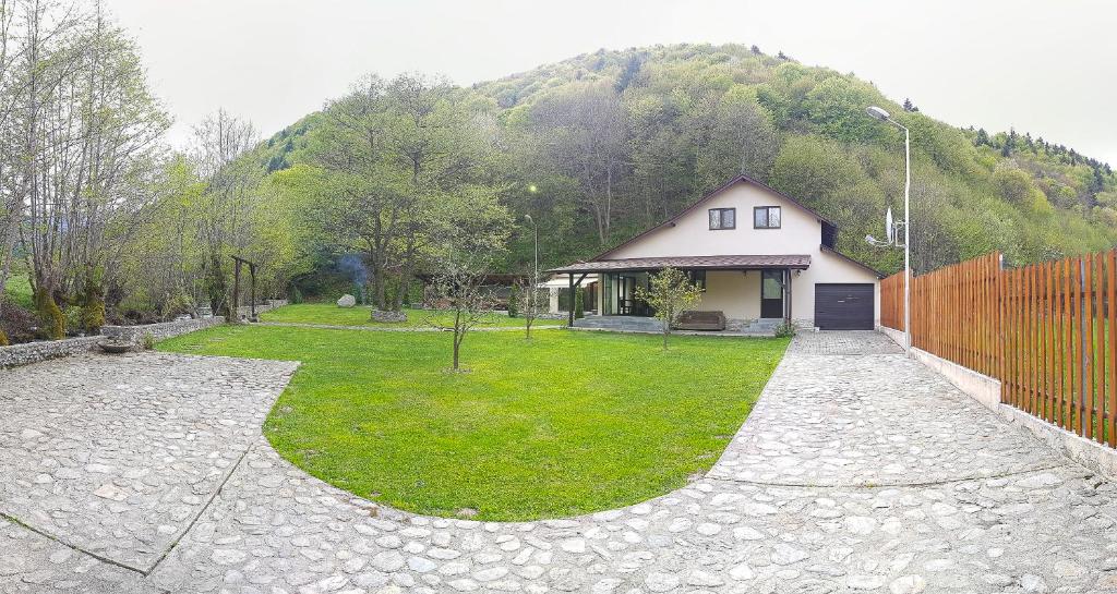 una casa frente a una montaña con un patio en Pensiunea Tudor Breaza, en Breaza
