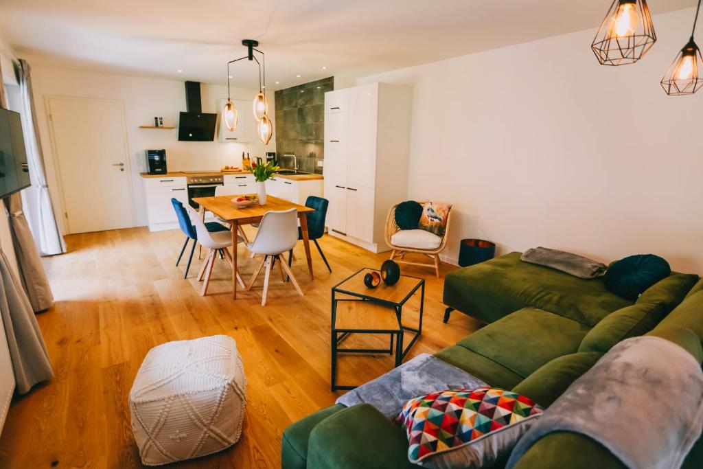 Rieslingresidenz في ترابن ترارباخ: غرفة معيشة مع أريكة خضراء وطاولة
