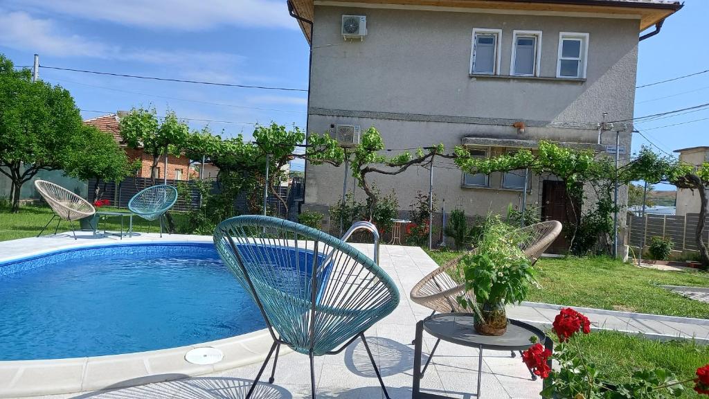 un patio con sillas, una piscina y una casa en КЪЩА ЗА ГОСТИ ПРИЯТЕЛИ, en Novo Delchevo